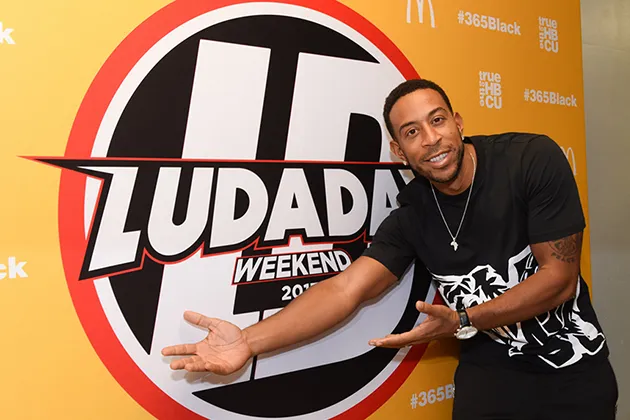 Ludacris smiles and gestures to a logo behind him reading 'LudaDay Weekend 2017.'